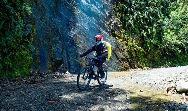 Человек на велосипеде на солнечной боливийской дороге смерти
 - Фото, изображение