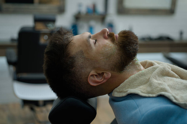 Beard care. Barber scissors and straight razor barber shop. Advertising and barber shop concept. Senior man visiting hairstylist in barbershop. Beard styling and cut. Bearded man or hipster. - Фото, зображення