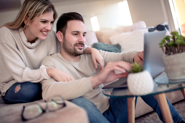 Casal jovem relaxante no sofá com laptop.Love, felicidade, pessoas e conceito divertido
. - Foto, Imagem