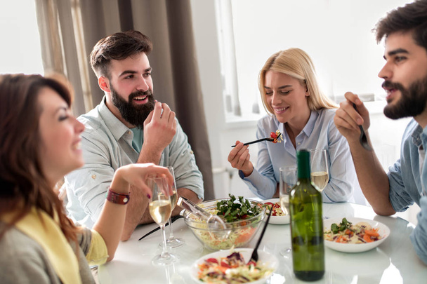 Group of friends celebrate with alcohol and food at home party. - Φωτογραφία, εικόνα
