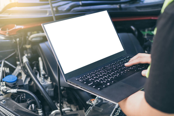 Close up engineer  mechanic using electrnoic diagnostic equipment to tune a car, Laptop blank screen. - Foto, afbeelding