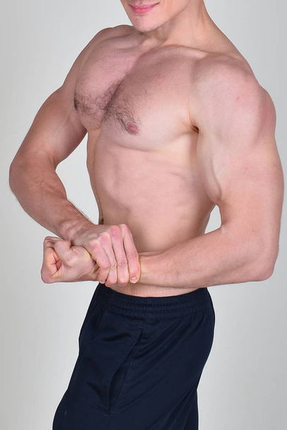 Muscular male torso of bodybuilder on white background - 写真・画像