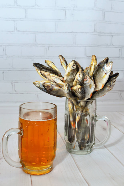  Ryby suszone i piwo na drewnianym stole  - Zdjęcie, obraz