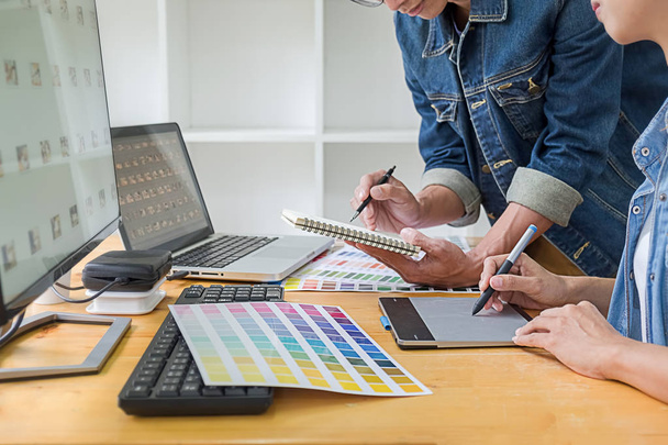 Graphic design with color swatches and tablet on a desk. Graphic designer drawing something on tablet at the office with work tools and accessories. - Photo, Image