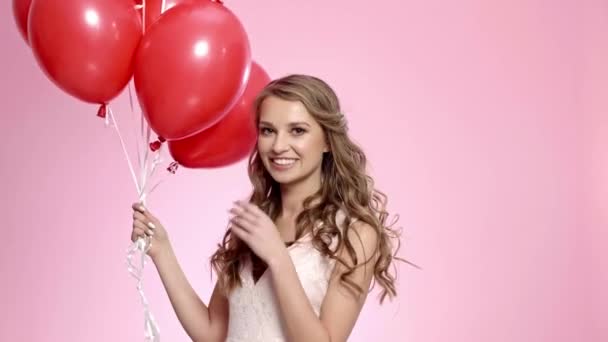 Happy woman with red balloons blowing a kiss - Footage, Video