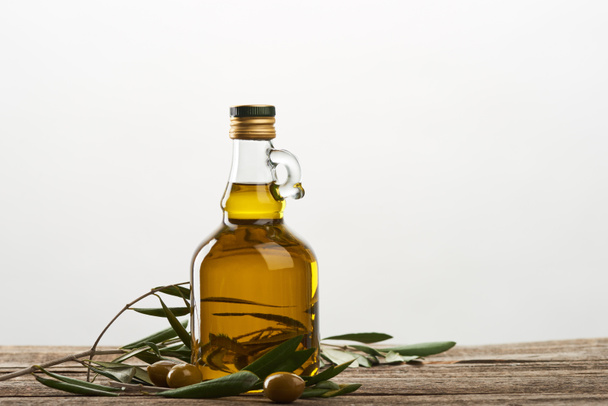 oil bottle with olive tree leaves and olives isolated on grey  - Photo, Image