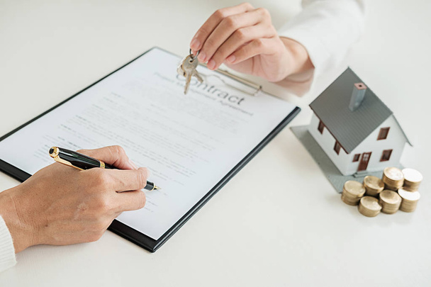 Immobilienmakler und Kunde unterzeichnen Vertrag zum Kauf von Immobilien, Versicherungen oder Krediten. - Foto, Bild
