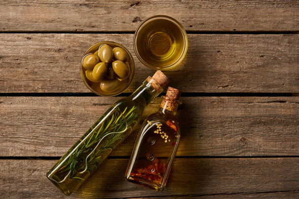 vue de dessus de aromatisé, et bols avec de l'huile et des olives sur la surface en bois
 - Photo, image