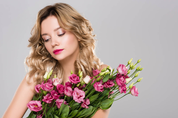 attractive woman with bouquet of Eustoma flowers isolated on grey - 写真・画像