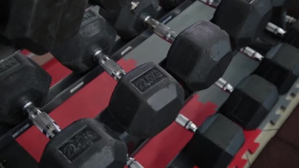 Kurzhanteln für das Training liegen im Fitnessstudio auf dem Gepäckträger. - Filmmaterial, Video