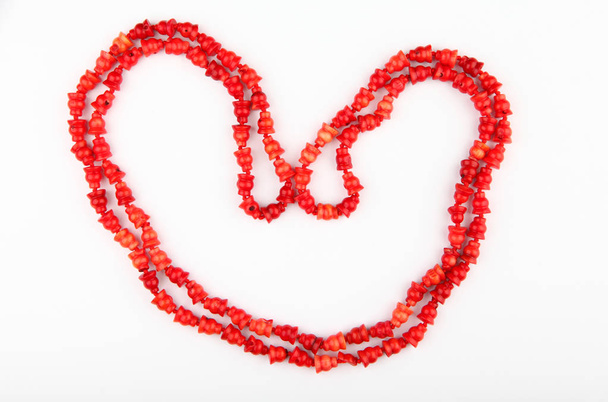 red beads heart symbol white background studio  - Valokuva, kuva