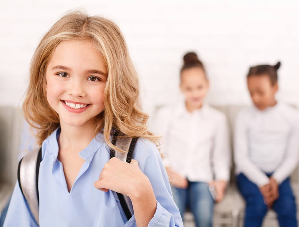 glückliche Schulmädchen mit Klassenkameraden im Hintergrund - Foto, Bild