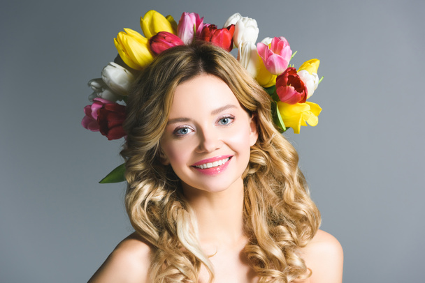 happy girl with wreath of flowers on hair isolated on grey - Photo, Image