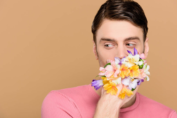 man covering mouth with flowers isolated on beige - Foto, immagini