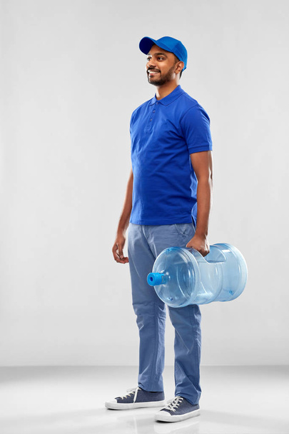 happy indian delivery man with water barrel - 写真・画像