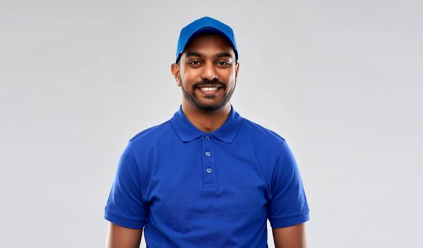 happy indian delivery man in blue uniform - Фото, зображення