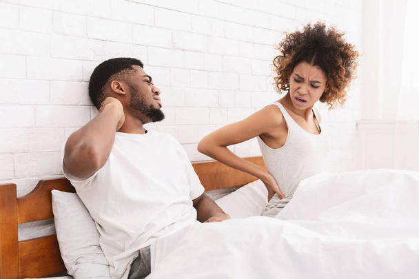 Couple afro-américain souffrant de maux de dos et de cou au lit
 - Photo, image