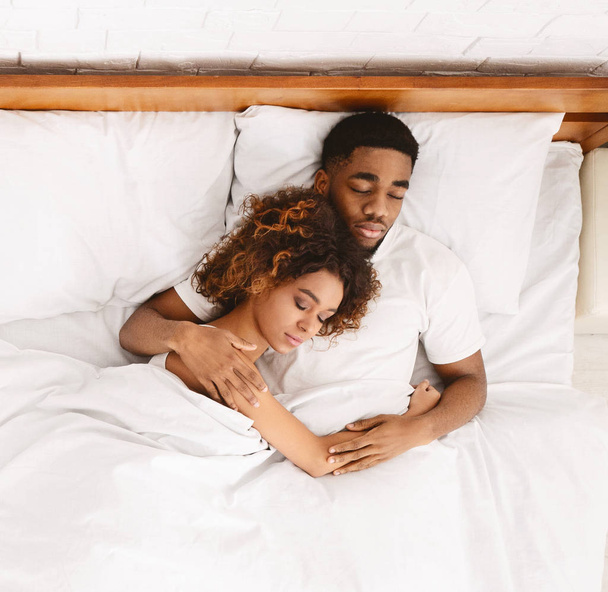 Verliefde paar slapen in bed en knuffelen - Foto, afbeelding