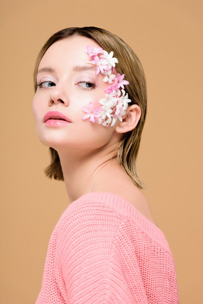 thoughtful girl with flowers on face isolated on beige - Photo, Image