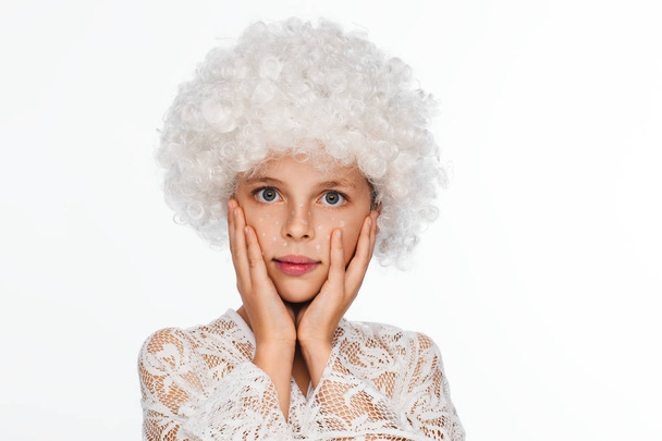 Portrait of a cheerful, energetic eight-year-old girl in a white wig and with white freckles. White background - Foto, Imagen