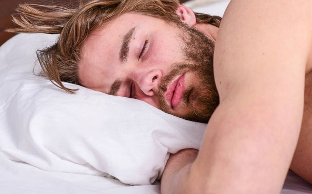 Man handsome guy lay in bed. Get adequate and consistent amount of sleep every night. Expert tips on sleeping better. Bearded man sleeping face relaxing on pillow. How much sleep you actually need - Foto, Imagen