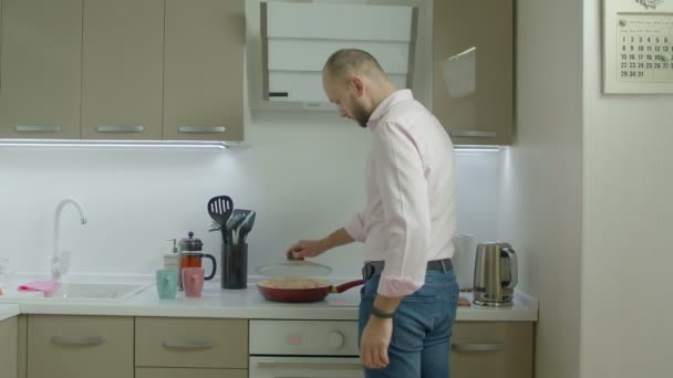 Single man cooking omelet for breakfast in kitchen - Πλάνα, βίντεο