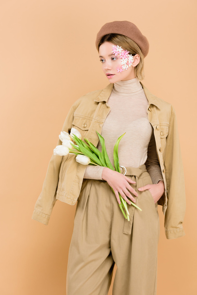 attractive woman in beret holding bouquet isolated on beige  - Foto, Imagem