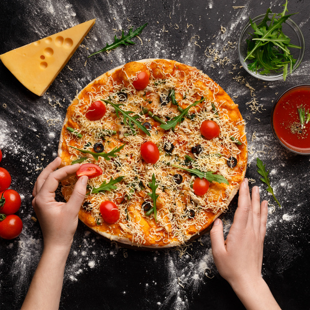 Szef kuchni dekorowanie pizza z pomidorami cherry, upraw - Zdjęcie, obraz