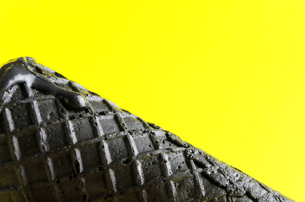 Κοντινό πλάνο της μαύρο γκοφρέτα κίτρινο φόντο. Κενό χώρο για το κείμενο - Φωτογραφία, εικόνα