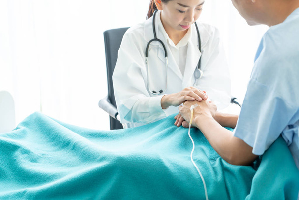 Hand of female doctor reassuring on her senior patient - selective focus point - Foto, Imagem