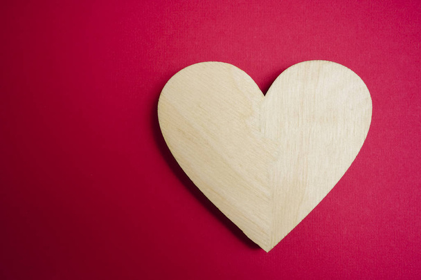 one wooden heart on on red background. i - 写真・画像