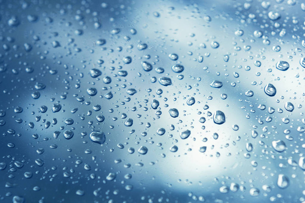 El agua real cae sobre fondo de gradación azul, se cierra. Las precipitaciones en el cristal de la ventana. Condenación - Foto, Imagen
