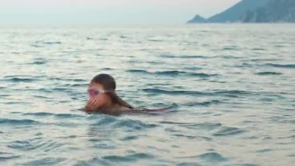 Молода дівчина вчиться плавати під водою. Дитина у водяній масці пірнає під водою
 - Кадри, відео