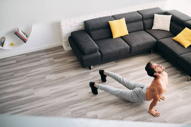 Hombre practicando yoga en casa haciendo rutina de saludo al sol
 - Foto, Imagen