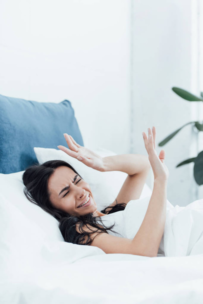 Irritated brunette woman lying in bed with closed eyes - Fotografie, Obrázek