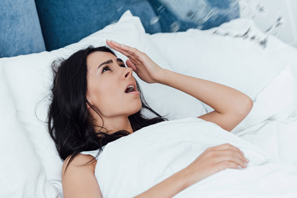 Šokovaná žena v posteli se zabývá poškození vodou - Fotografie, Obrázek