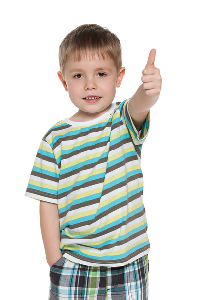 Little boy in striped shirt holds his thumb up - Фото, изображение