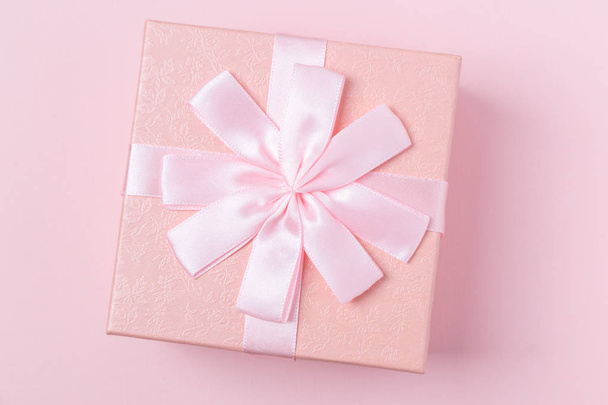 Coffret cadeau décoratif rose avec arc sur fond rose
 - Photo, image