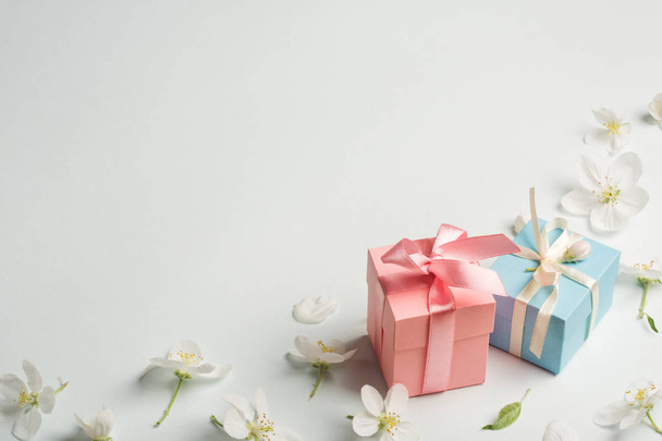 two gifts surrounded by Apple white flowers. blue and pink presents. pretty background. - Foto, afbeelding