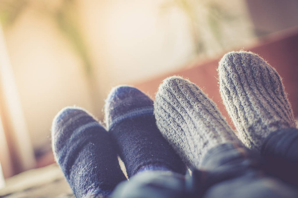 Feet with woollen socks in the wintertime: Couple is relaxing on the couch - Фото, зображення