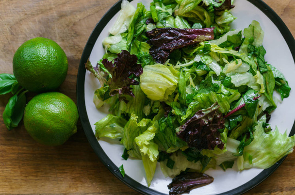 Taze salata yeşillikleri, zeytinyağı ve limon ile limon suyu ile terbiyeli farklı türdeki - Fotoğraf, Görsel