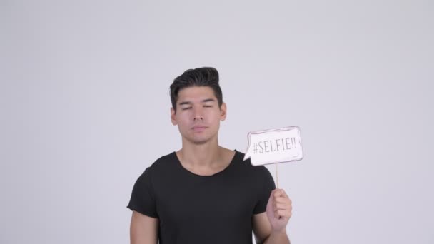 Happy young handsome multi-ethnic man with selfie paper sign - Video