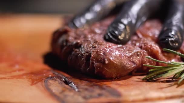 Hand in black gloves cutting meat steak with knife close up. - Felvétel, videó