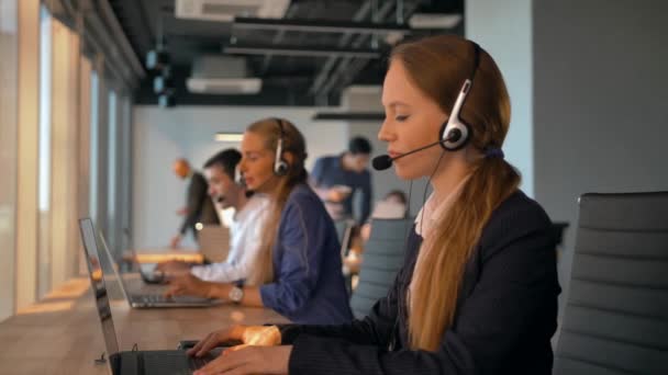 Vezetékes fülhallgatóval rendelkező női ügynök call centerben. - Felvétel, videó
