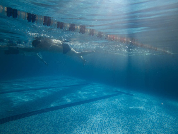 Menschen, die in Poolblick vom Unterwasser aus schwimmen. Sportlicher Lebensstil - Foto, Bild