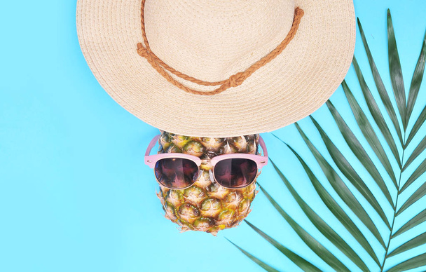 Palm leaf, pineapple and hat. Summertime background. Vacation concept. - Photo, Image