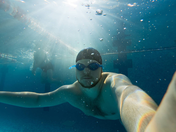 az ember víz alatti gazdaság levegőt medencében. kék szemüveg - Fotó, kép