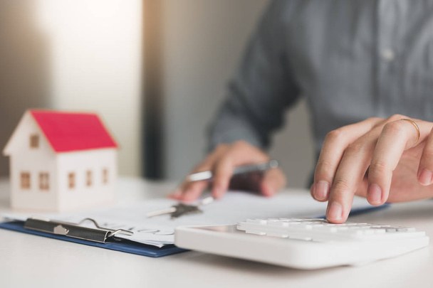 Les agents à domicile utilisent une calculatrice pour calculer la période de prêt chaque mois pour le client
. - Photo, image