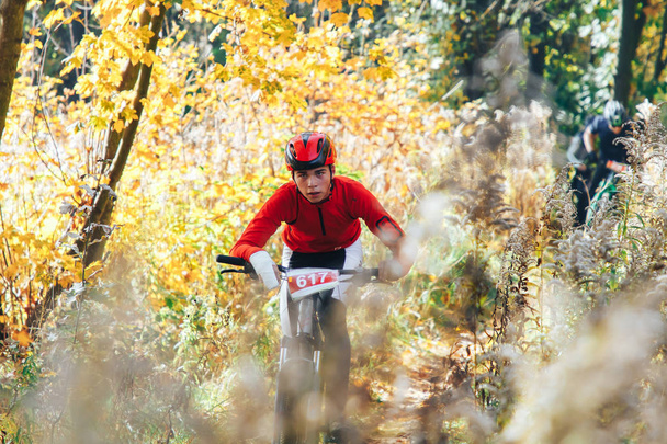 October 14, 2018 - Minsk, Belarus: 2018 Olympic Cross Country Cup XCO in Medvezhino, teenager boy riding bicycle on forest trail during race - 写真・画像