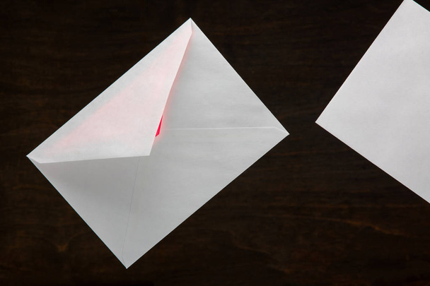 Valentine's Day Card. Mailing envelope with a red glow from the inside on a dark wooden background - Foto, immagini